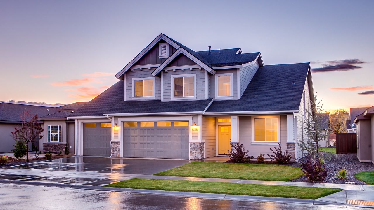 Source photograph of a blue and gray house at twilight, with its front door, garage and windows